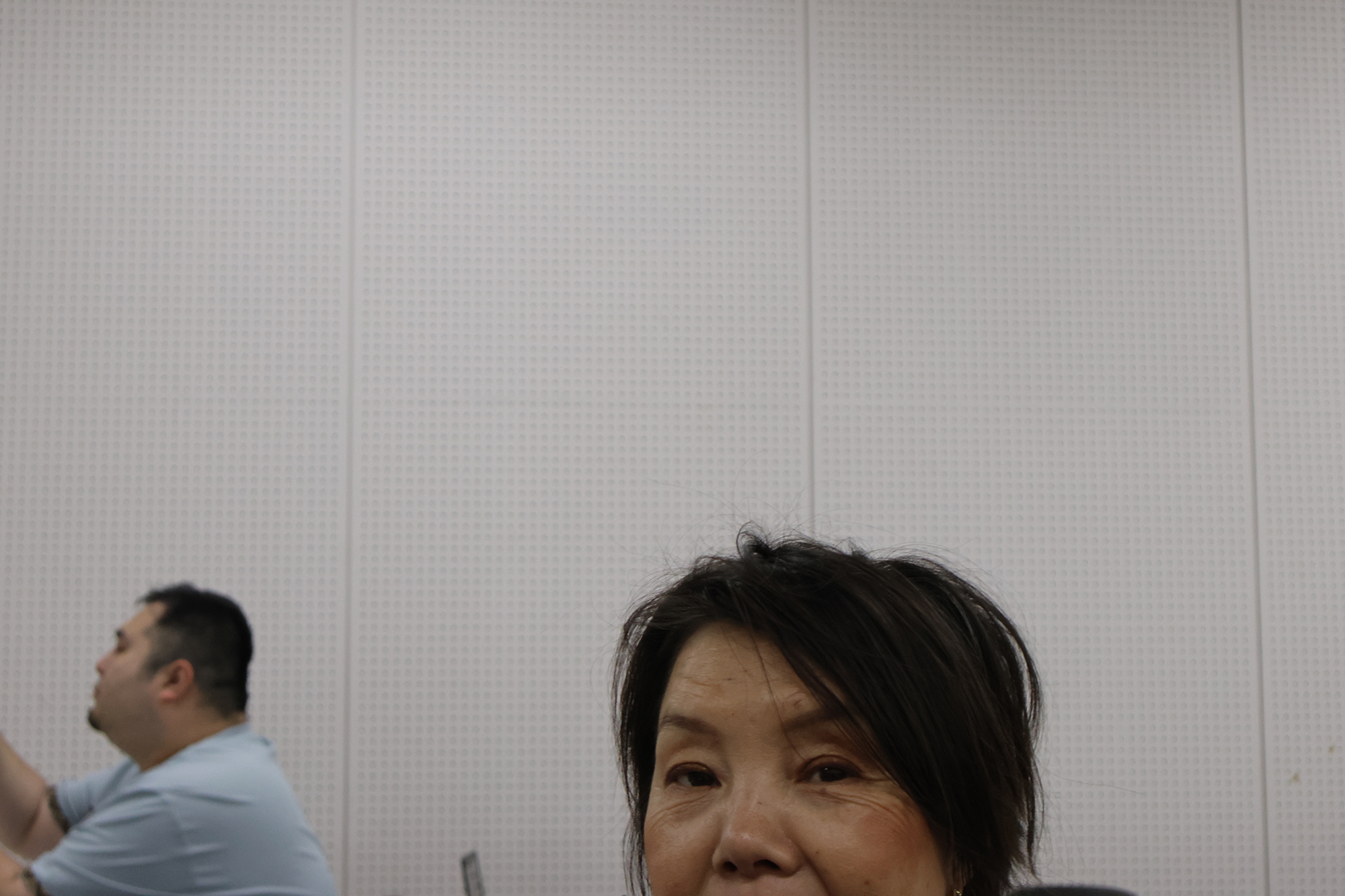 カメラのほうを向いた竹田さんの表情を捉えた一枚。口元から下は画面の外にはみ出し、顔の上半分が写っている。