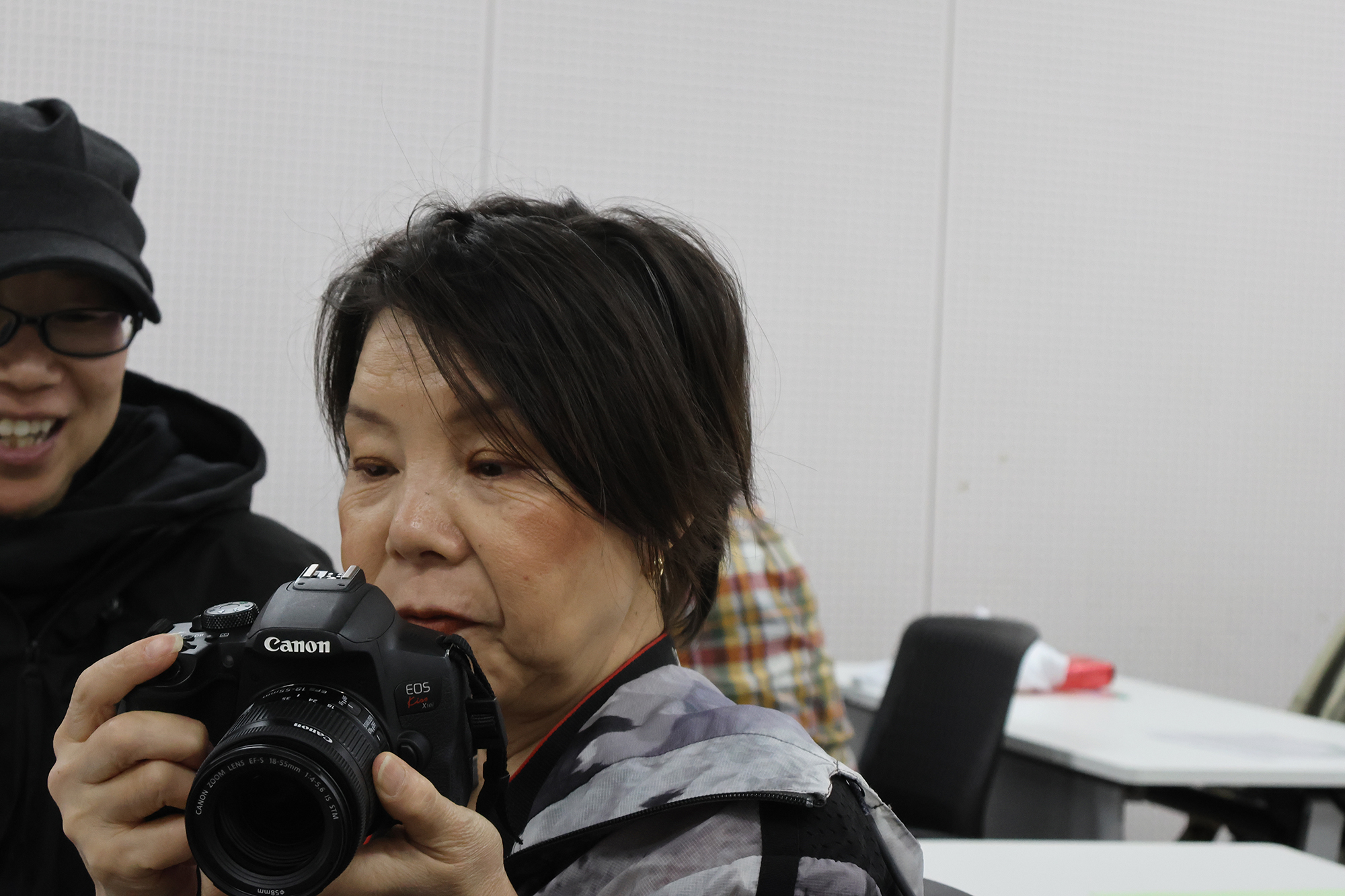 カメラを手に、一眼レフのボタン配置やシャッター位置を確かめながら操作する竹田さん。
