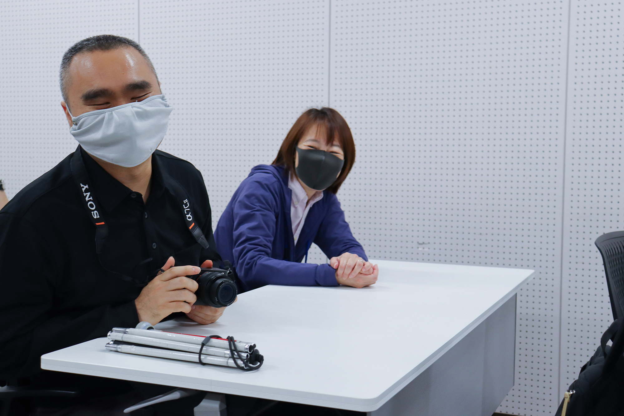 カメラを手に笑顔を見せる濱崎さんと、隣で微笑むガイドさん。