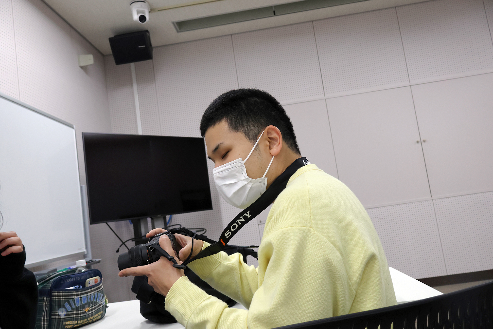 カメラのボタンやレンズの位置を触って確認する安田さん