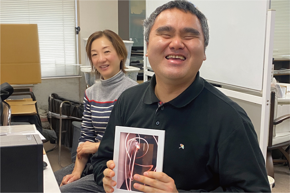 ワークショップで制作した写真作品を手に笑顔を見せる参加者